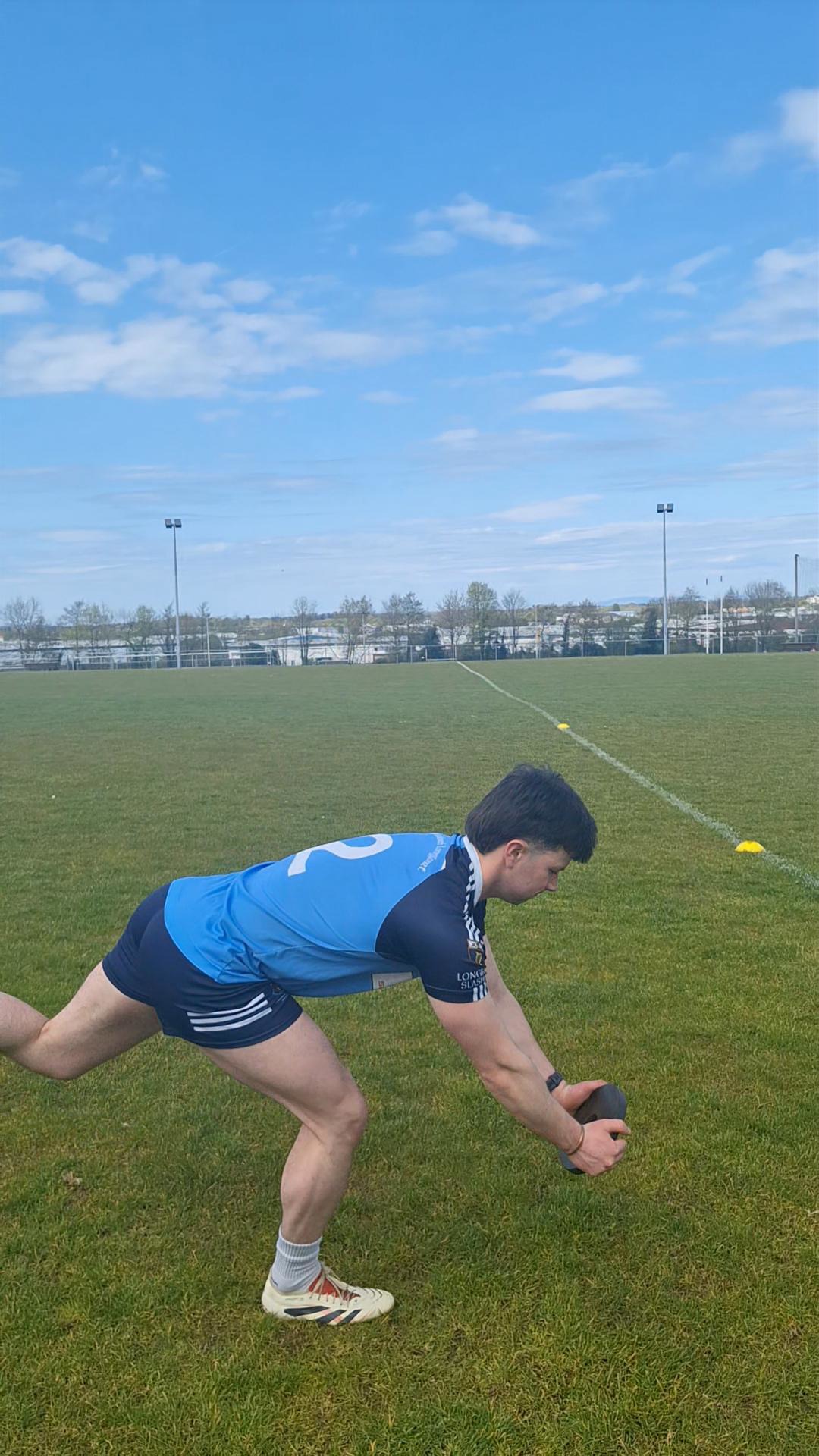 Athlete performing a medicine-ball strength drill on the field