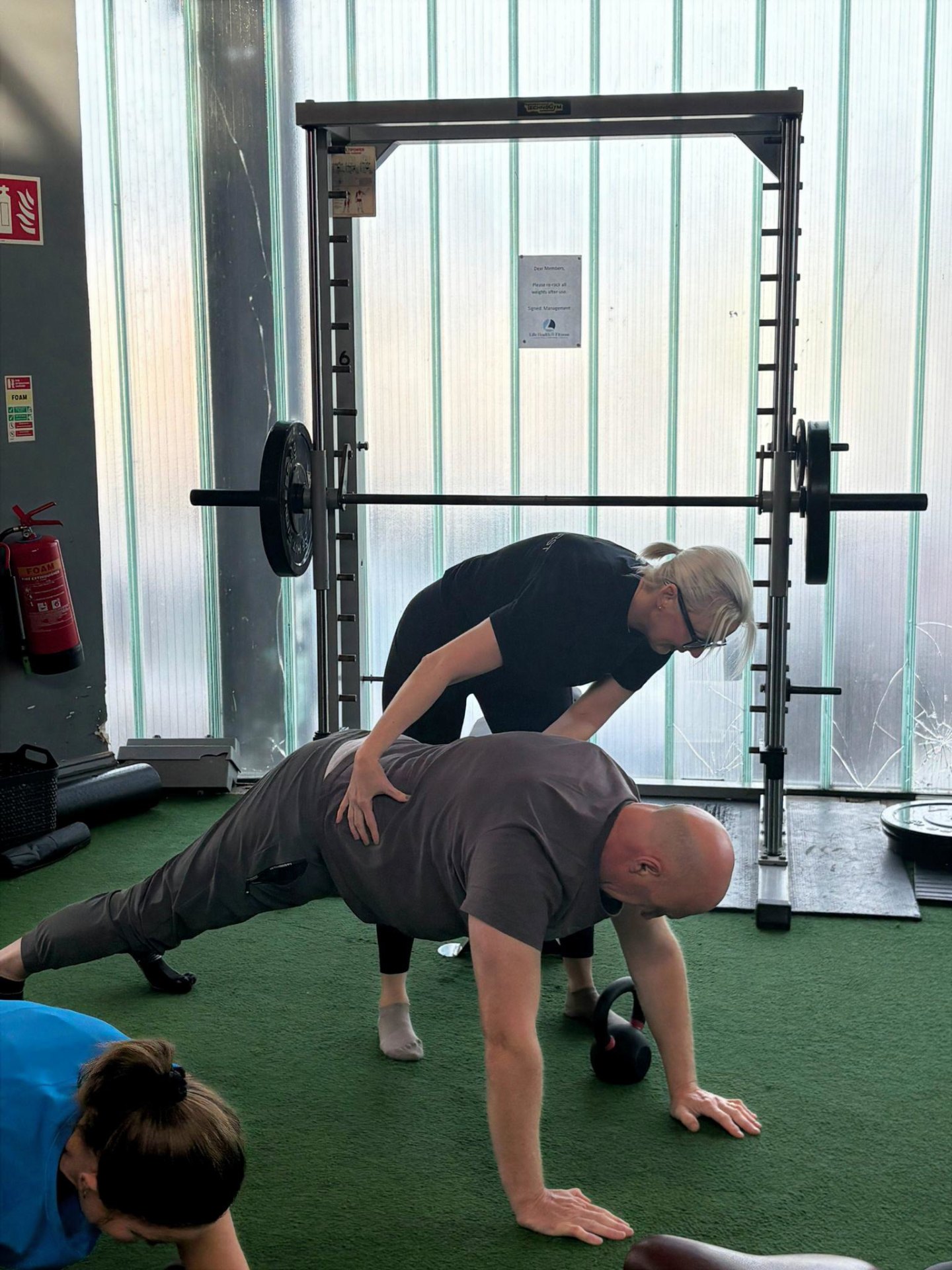 Riona coaching a client through a plank exercise