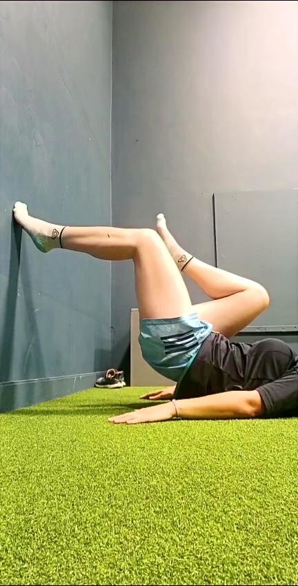 Athlete performing a wall-supported bridge exercise