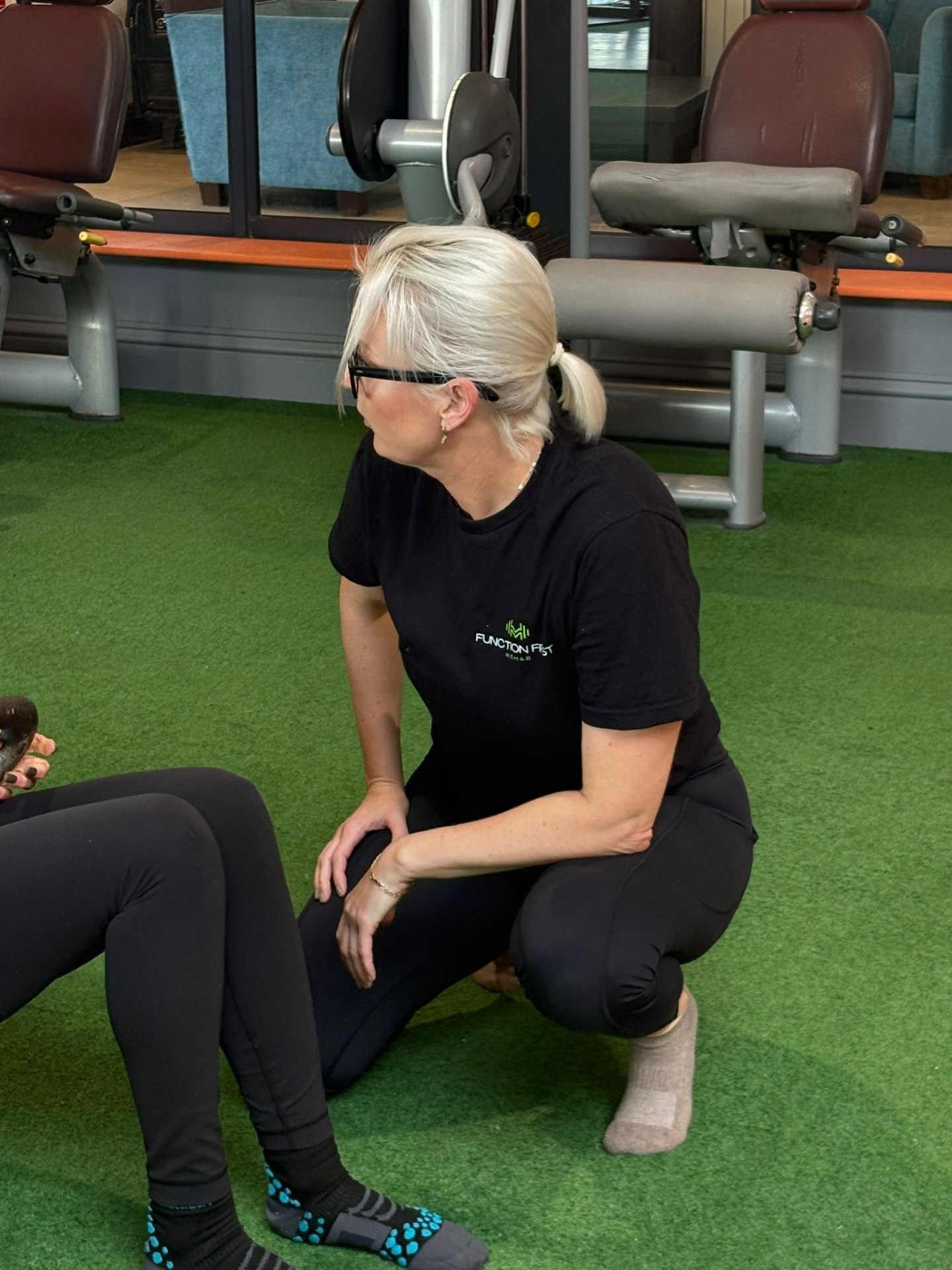 Riona coaching a client during a floor exercise