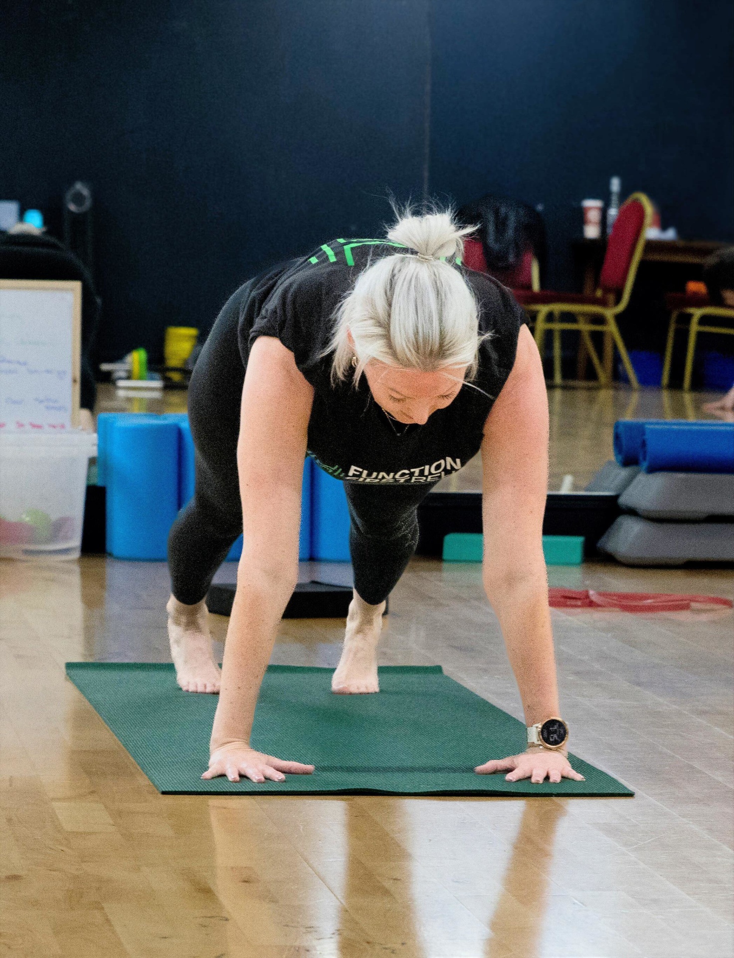 Riona demonstrating a movement on a mat in front of the class