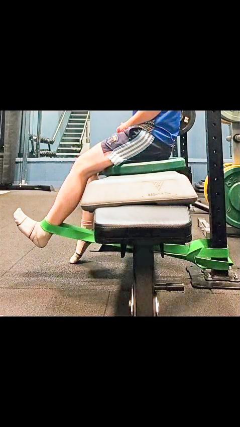 Client completing seated ankle strengthening with a band