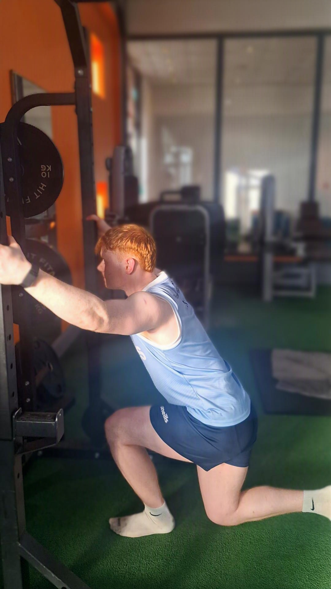 Athlete performing a supported split lunge in the gym