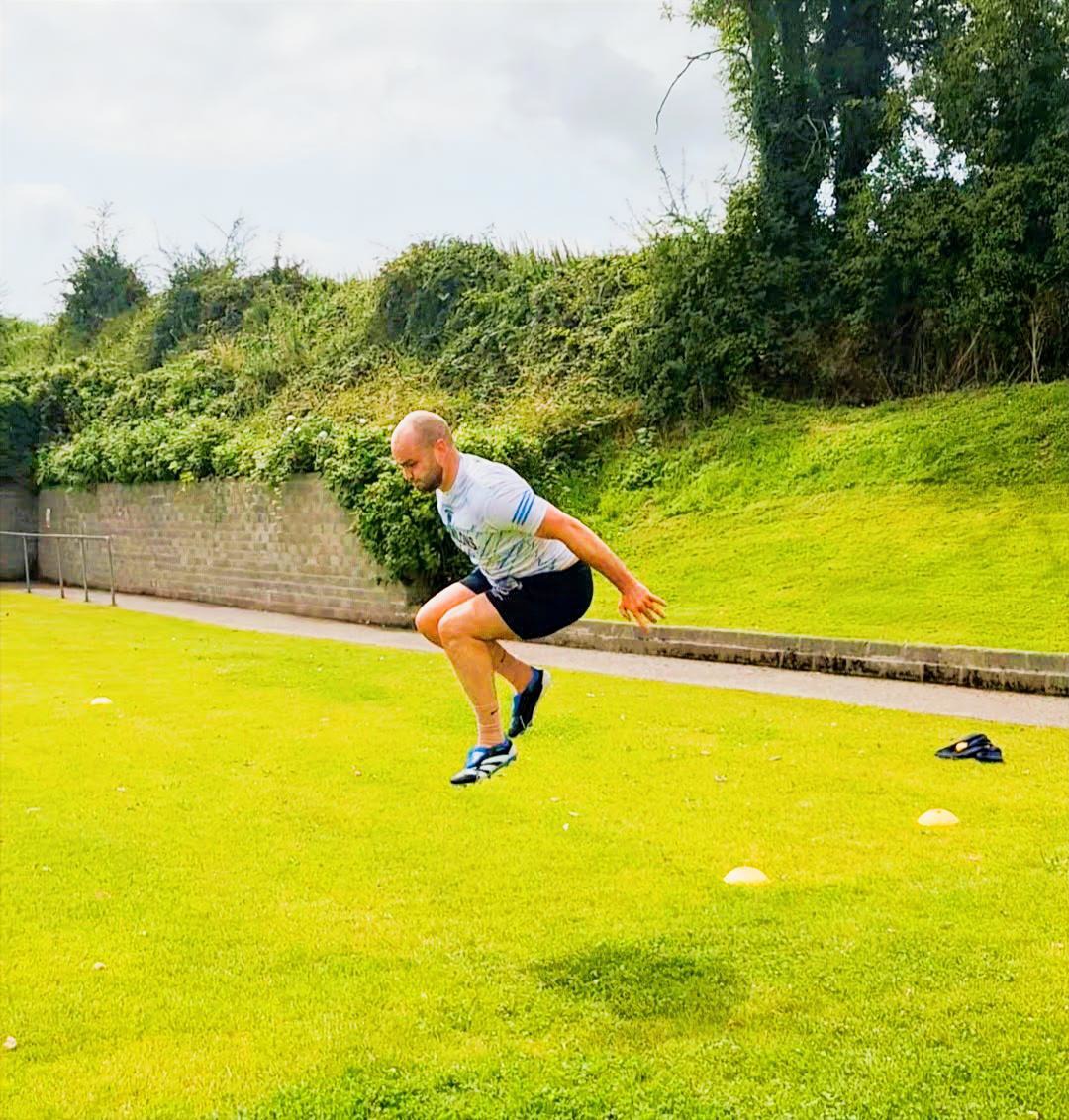 Client performing plyometric drills outdoors on the field