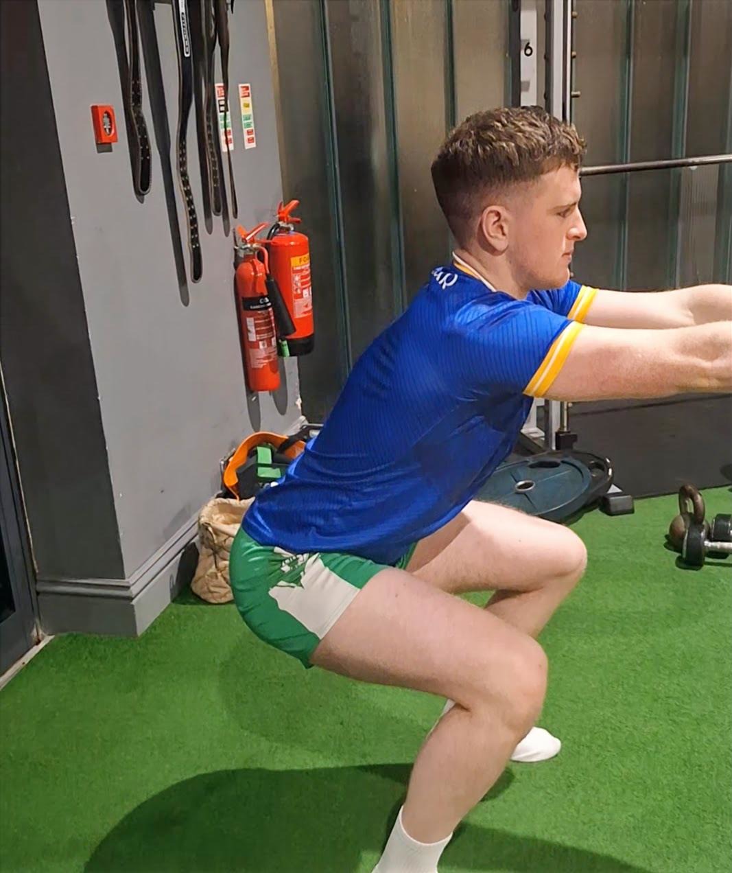 Athlete practising squat mechanics during rehabilitation