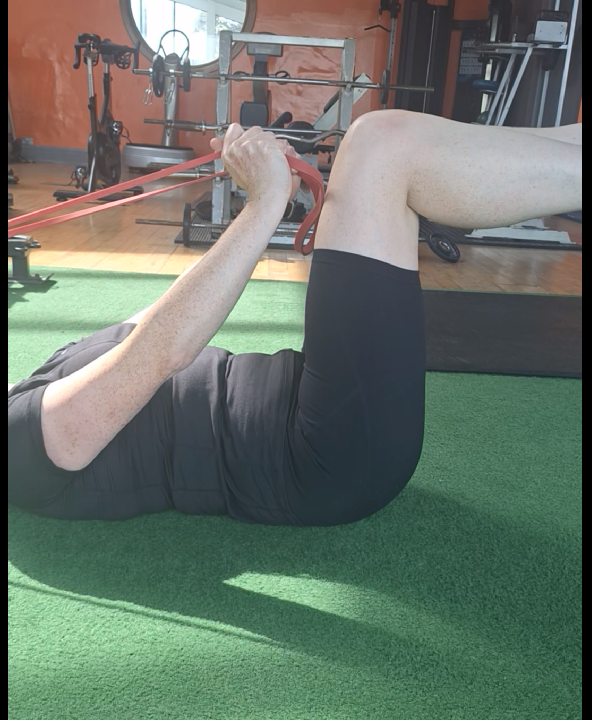 Client completing assisted hip mobility with a resistance band