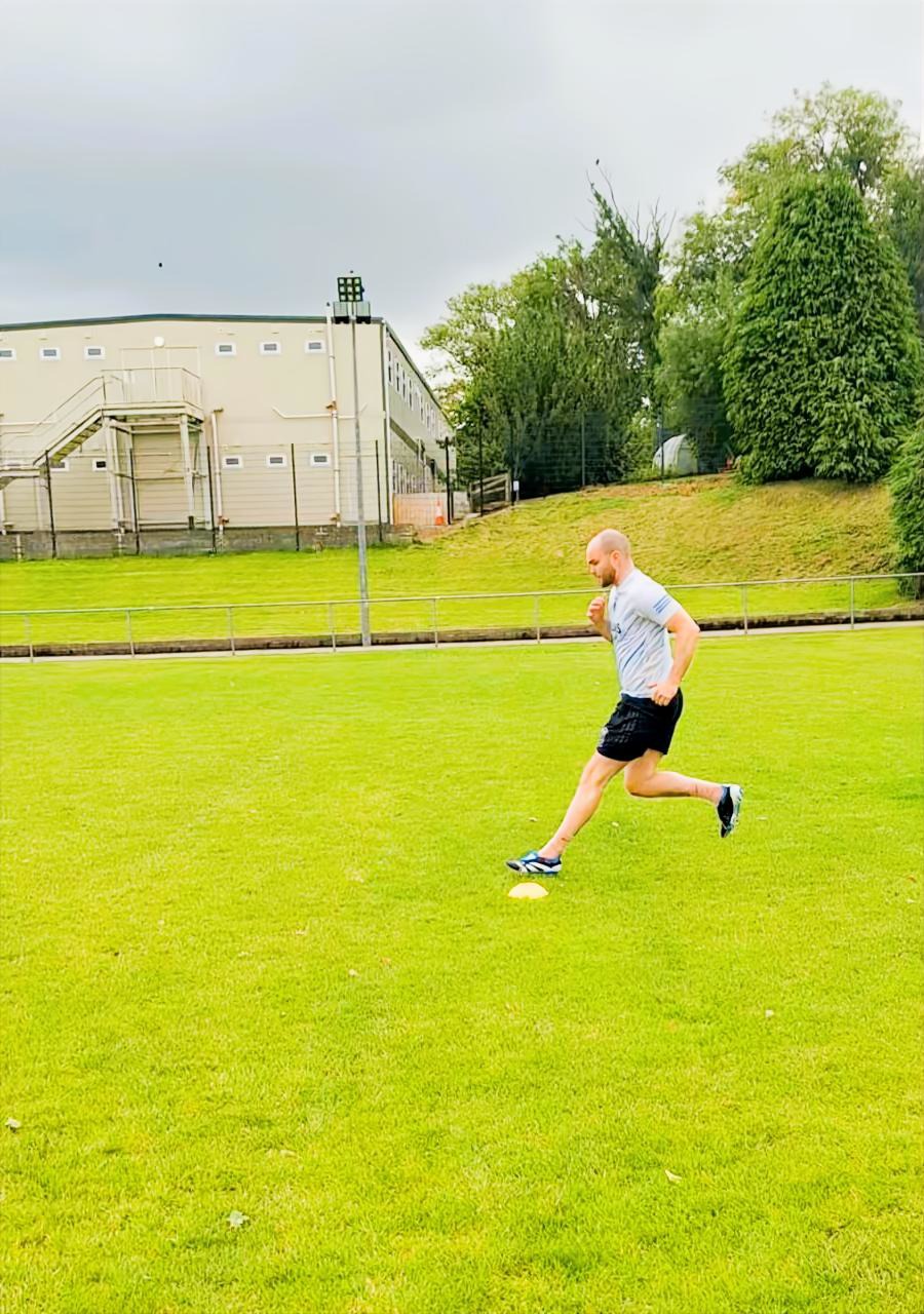 Athlete accelerating through a cone drill on the field