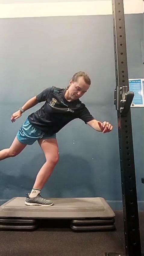 Athlete balancing on a raised step during rehabilitation