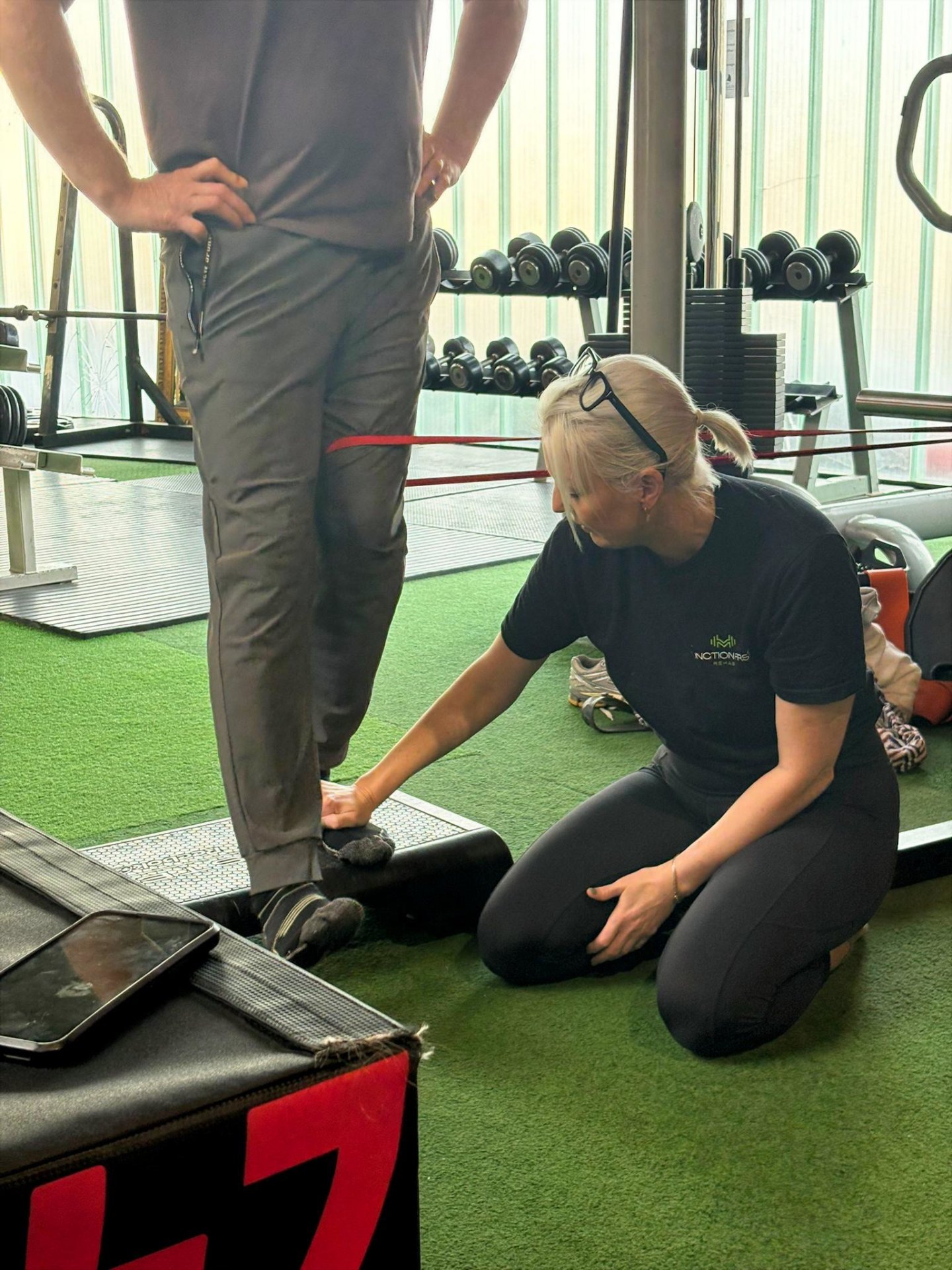 Riona assessing a client's foot position during a step exercise